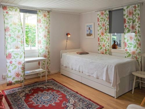 a bedroom with a bed and a red rug at Holiday home Smögen IV in Smögen