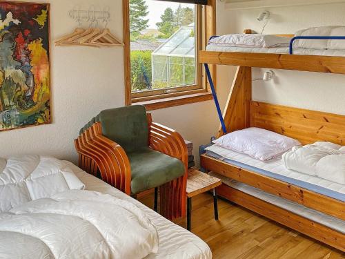 - une chambre avec 2 lits superposés et une chaise dans l'établissement Holiday home Skibby XIV, à Skibby