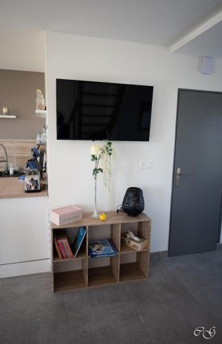 a living room with a television on a wall at GITE ARC EN CIEL BLEU in Férel