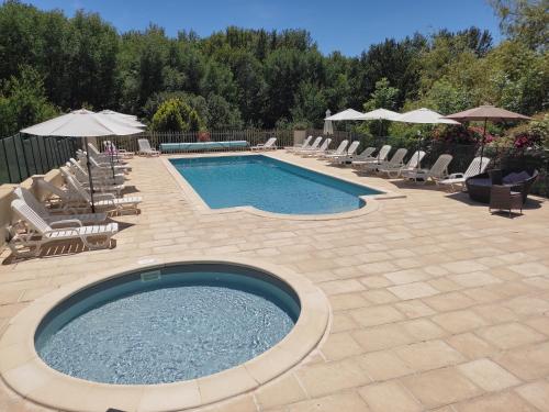 a swimming pool with chairs and umbrellas at Pagel in Catus