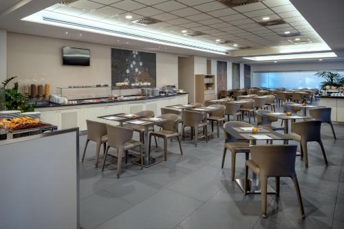 a restaurant with tables and chairs in a room at UNA Hotels Bologna Fiera in Bologna