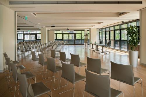 a large room with chairs and tables and windows at UNA Hotels Bologna Fiera in Bologna