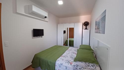 バーハ・ヴェーリャにあるPé na areia em Vila Açoriana, a 20min do Beto Carreroのベッドルーム1室(ベッド1台、緑の毛布付)
