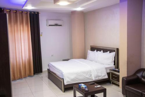 a small hotel room with a bed and a chair at Sara Crown Hotel in Irbid