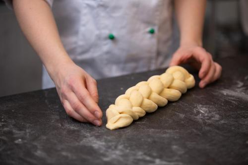 a woman is making a pile of dough on a counter at Pension Cäcilia in Pöllau
