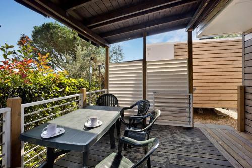 a table and chairs on a wooden deck at Mobile Home Ulivi 147 in Pietra Ligure