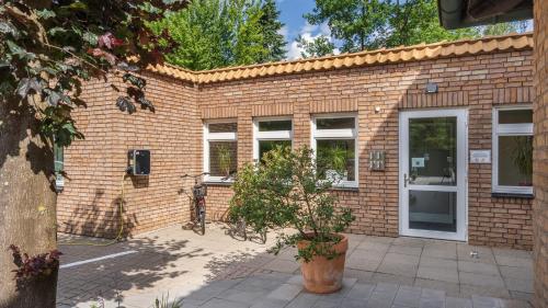 a brick building with a plant in front of it at Hotel Kreuzer in Wedel