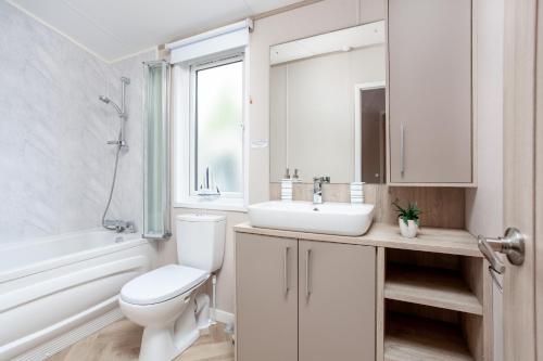 a white bathroom with a sink and a toilet at Lakeside Lodge, Green Hill Farm Holiday Village in Salisbury