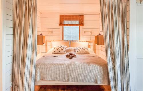 a bedroom with a bed with curtains and a window at 2 Bedroom Nice Home In Bottnaryd in Bottnaryd