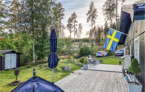 a patio with an umbrella and a flag on a house at 2 Bedroom Nice Home In Bottnaryd in Bottnaryd