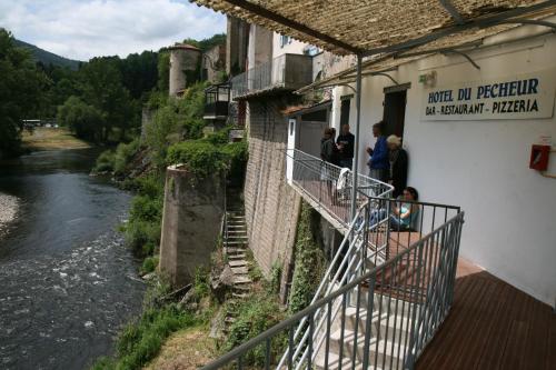 a group of people standing outside of a building next to a river at Hôtel Restaurant du Pêcheur in Lavoûte-Chilhac