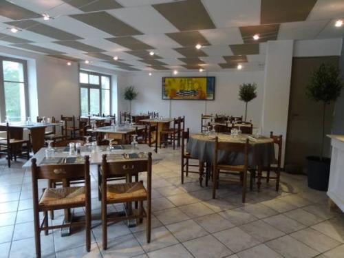 a dining room with tables and chairs in a restaurant at Hôtel Restaurant du Pêcheur in Lavoûte-Chilhac