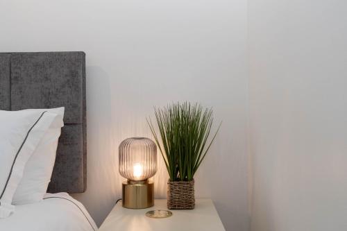 a lamp on a night stand next to a bed at Hale Lodge in London