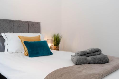a white bed with colorful pillows on top of it at Hale Lodge in London