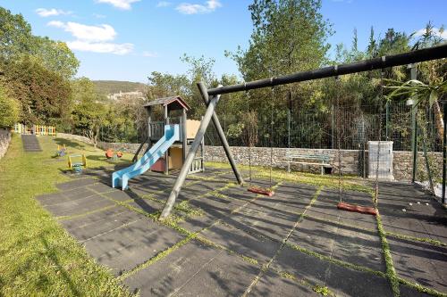 a playground with a slide in a yard at Mobile Home Charme 177 in Pietra Ligure