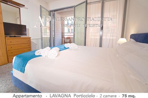 una camera con un grande letto bianco e una TV di Casa ANNETTE a Lavagna