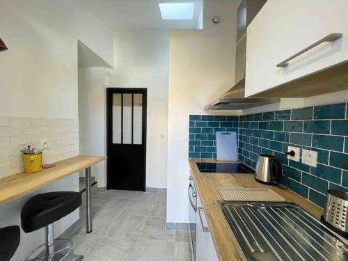 - une cuisine avec du carrelage bleu et une porte noire dans l'établissement Studio avec terrasse à deux pas du port, à Toulon