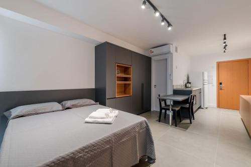 um quarto com uma cama, uma secretária e uma mesa em LIV - Apartamento 1205 em Porto Alegre