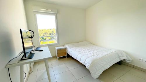 une chambre avec un lit, un bureau et une fenêtre dans l'établissement Sérénité, à Antibes