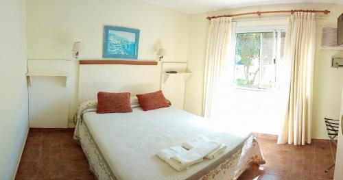 a bedroom with a bed with two towels on it at Apart Hotel Iken in Federación