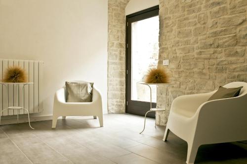 a living room with two white chairs and a window at Residence San Martino in Erice