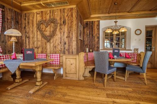 a dining room with wooden walls and wooden tables and chairs at Landhaus Sommerau in Buchenberg