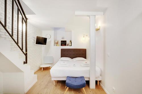 a white bedroom with a bed and a staircase at CMG Cavallotti - Montmartre in Paris