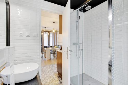 a bathroom with a shower and a white tub at CMG Cavallotti - Montmartre in Paris