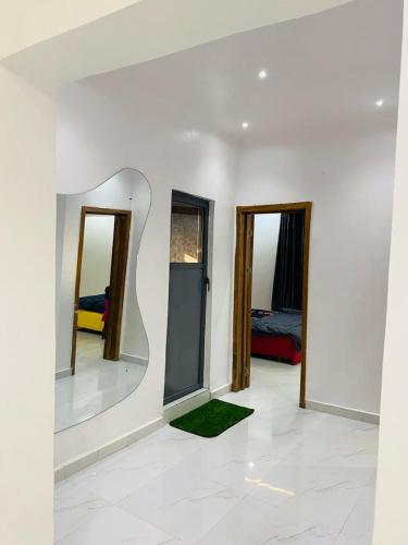 Chambre blanche avec 2 miroirs et un tapis vert dans l'établissement Mr Luxury 3 Bedroom Apartment, à Lagos