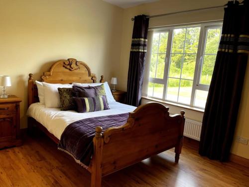 a bedroom with a bed and a large window at Drumbar Lodge in Carterʼs Bridge