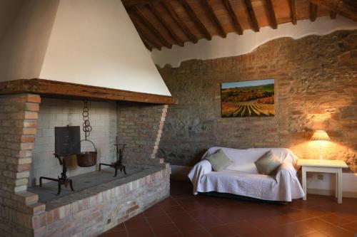 sala de estar con cama y chimenea en Podere San Giuseppe Montalcino, en Montalcino