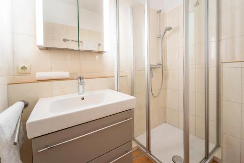 uma casa de banho com um lavatório e um chuveiro em Seepark Wohnung 1 1 em Scharbeutz