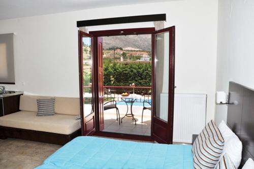 a bedroom with a bed and a balcony with a table at Actor Hotel in Ligourio