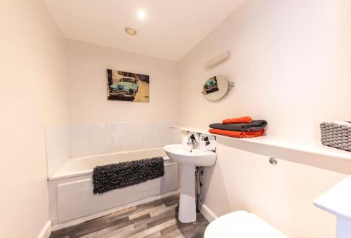 a bathroom with a sink and a toilet and a bath tub at Belfast Apartment in Belfast