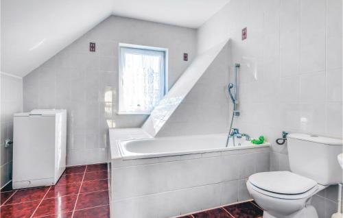 a bathroom with a toilet and a sink and a window at Stunning Home In Rowy With Sauna in Rowy