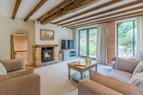 a living room with two couches and a fireplace at Barn End in Chipping Campden
