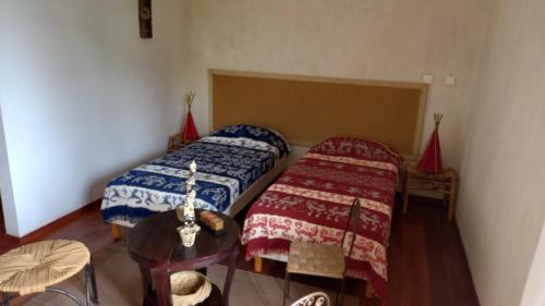 a small room with two beds and a table at Casa Azul in Mindelo