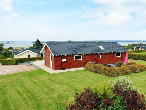 una casa roja con un gran patio delante en 6 person holiday home in Faaborg en Bøjden