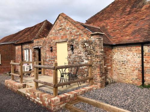 un edificio de ladrillo con puerta amarilla y porche de madera en The Barrel Room at The Northbrook Arms, en Winchester