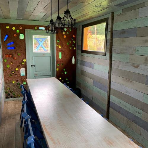 a table in a room with a wall with a window at Cinco Sentidos Hosteria in Villa Meliquina