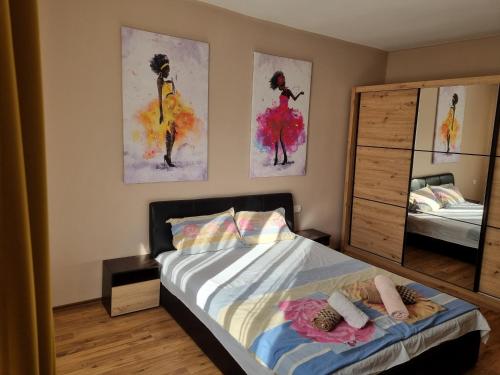 ein Schlafzimmer mit einem Bett und zwei Bildern an der Wand in der Unterkunft ELISA Apartment 20A Center-Skopje in Skopje