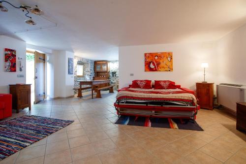 Un dormitorio con una cama con almohadas rojas. en IL COMO' DELLA CIVETTA - Taverna “La Fenice”, en Stazzona