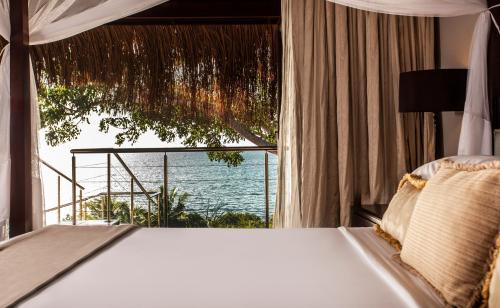 a bedroom with a bed and a view of the ocean at Anantara Bazaruto Island Resort in Bazaruto