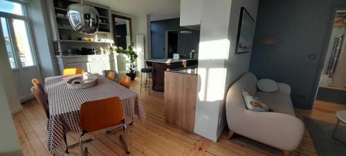 une cuisine et un salon avec une table et des chaises dans l'établissement Superbe appartement centre Wimereux, à Wimereux