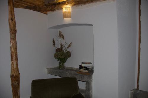 a room with a chair and a table with a plant at Maison Georges Couthon in Orcet