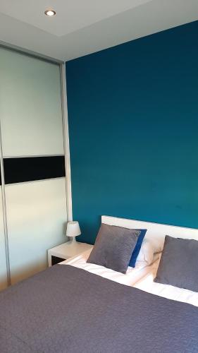 ein Schlafzimmer mit einem großen Bett mit blauer Wand in der Unterkunft Apartament LUXON 4 in Kielce
