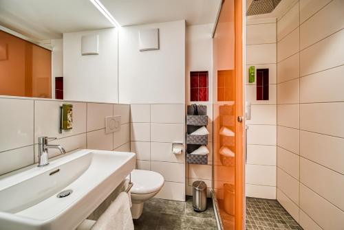 a bathroom with a sink and a toilet at Landhaus Sommerau in Buchenberg
