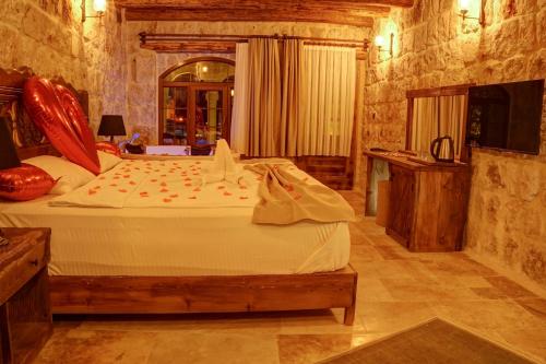 a bedroom with a large bed in a room at Dionysos Cave Cappadocia Hotel in Urgup