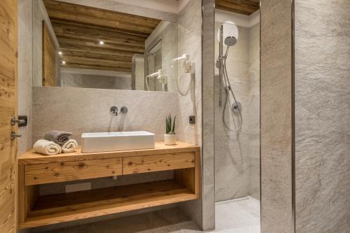 y baño con lavabo y ducha. en Appartements Chalet Bandiarac, en San Cassiano
