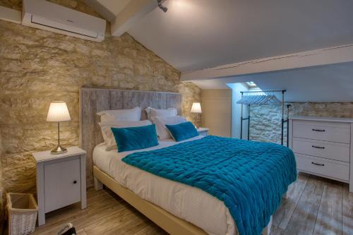 a bedroom with a large bed with blue pillows at Domaine des Pierres Blanches - Gite La Salamandre in Carlux